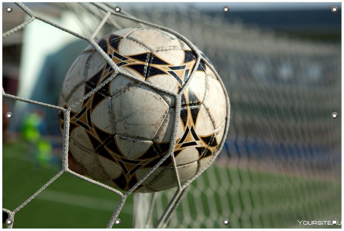 Футбольный мяч в сетке ворот фото