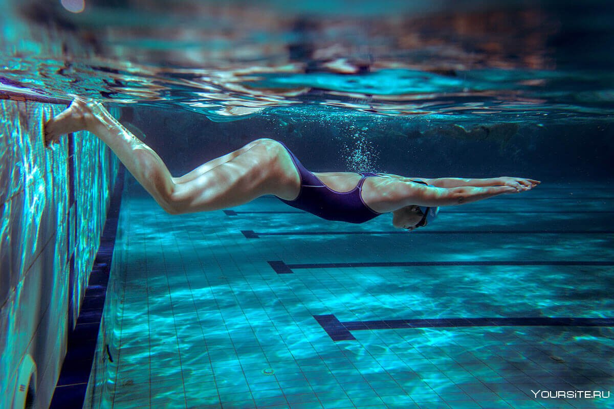 Человек под водой в бассейне