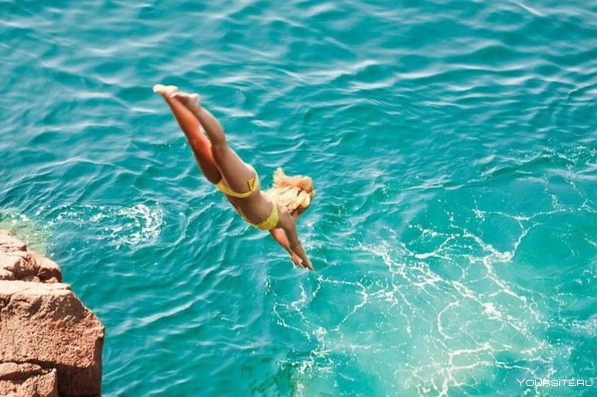 Девушка ныряет в море