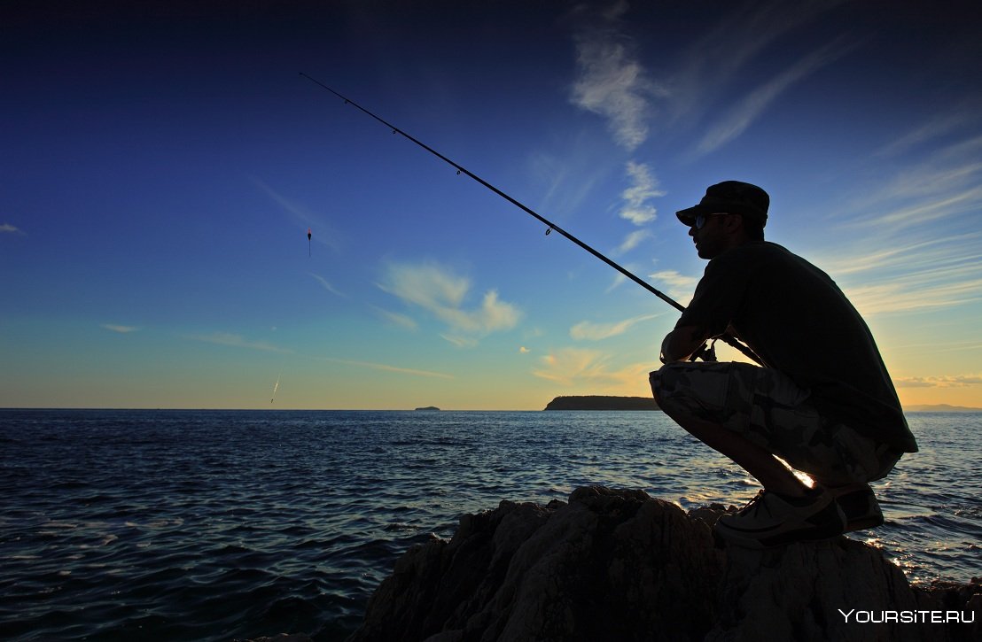 Мужчина с бородой на закате рыбачить