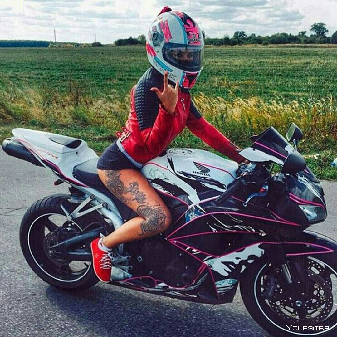 Девушка на спортивном мотоцикле в шлеме