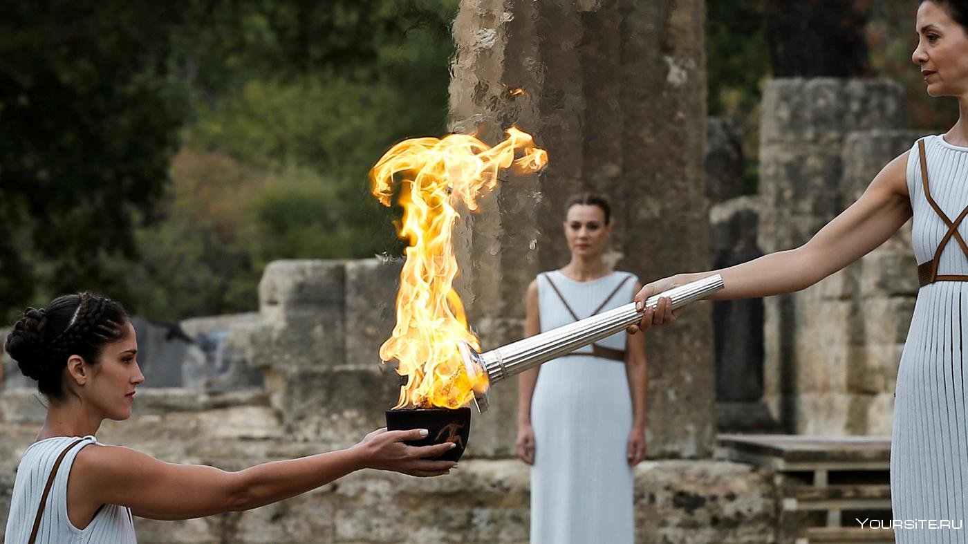 Олимпийский огонь современных игр зажигается. Зажжение олимпийского огня в древней Греции. Зажжение олимпийского факела Греция.