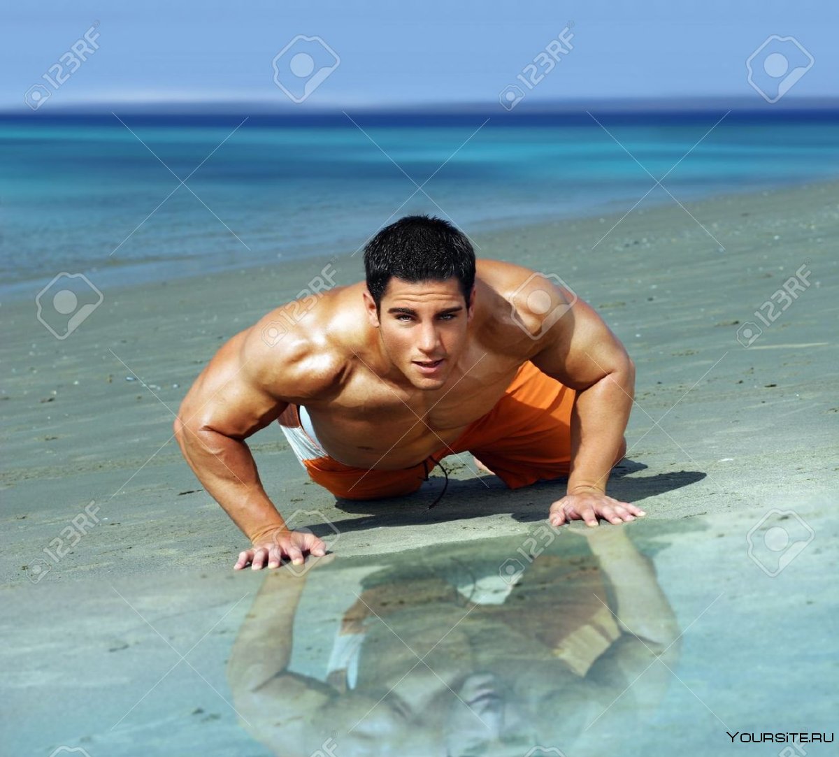Мужчина мускулистый на пляже лежит