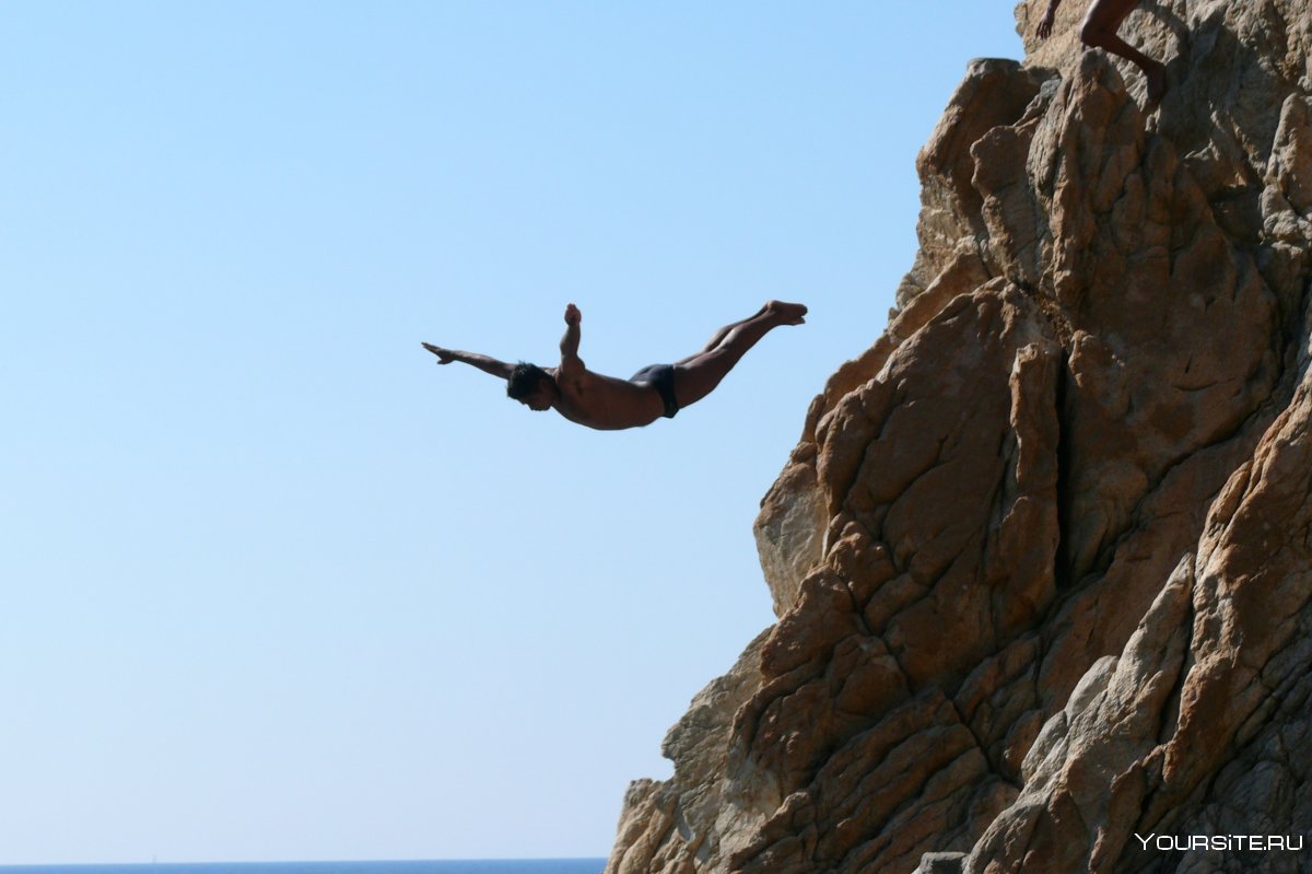 Человек прыгает со скалы