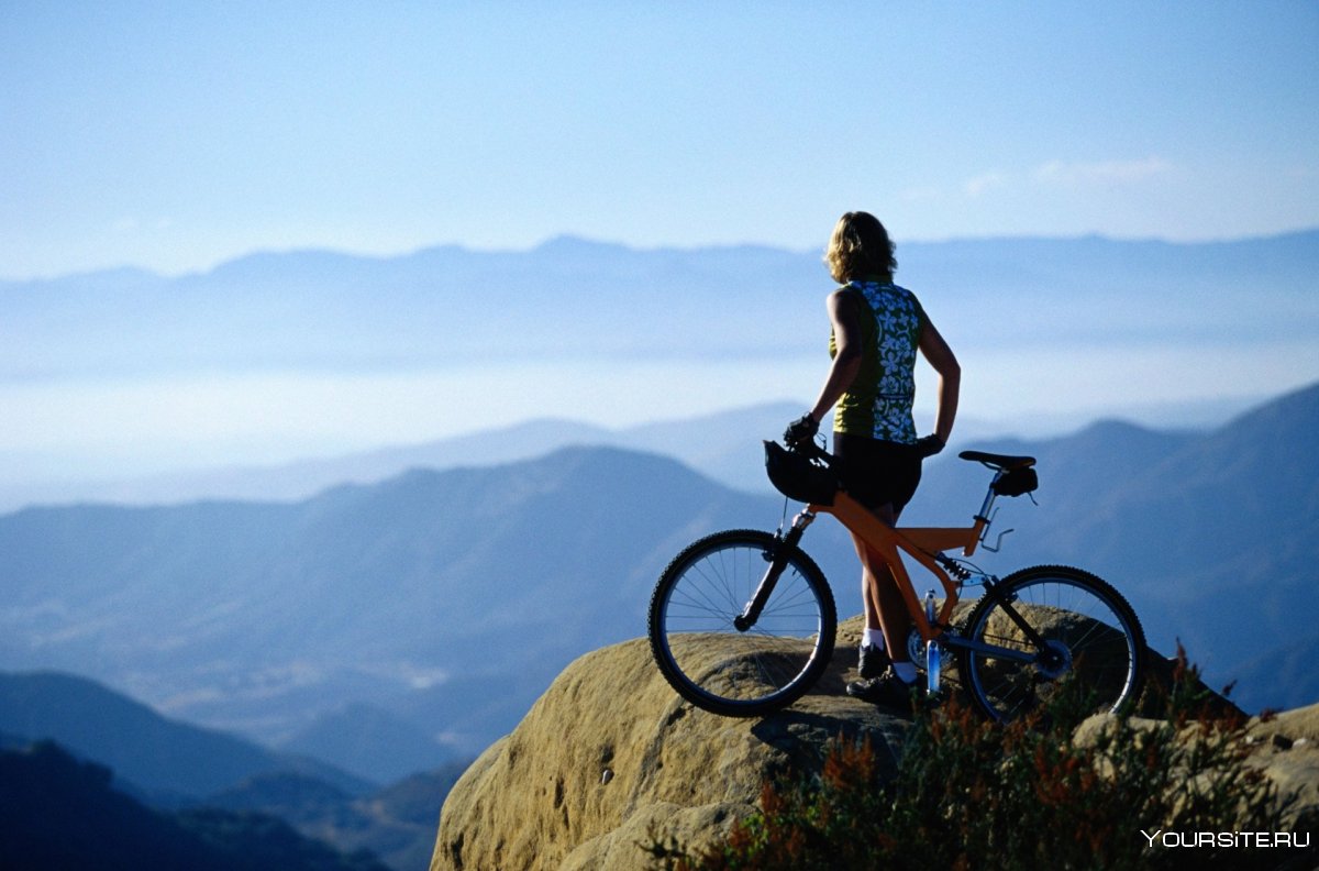 Девушка на велосипеде в горах
