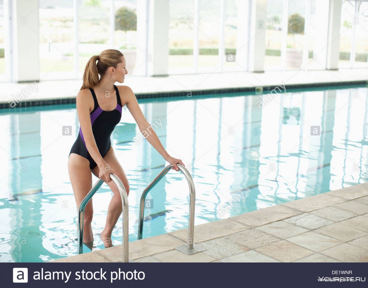 Девушка плавает в спортивном бассейне