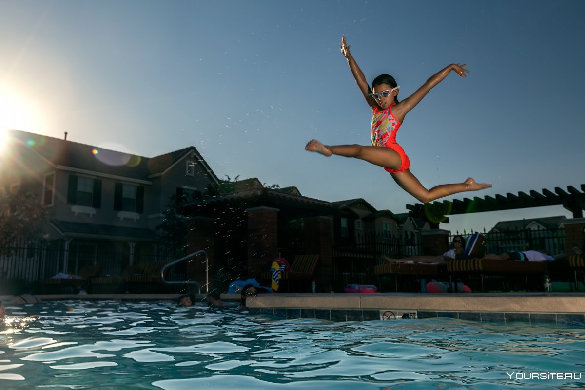 Девушка прыгает в бассейн