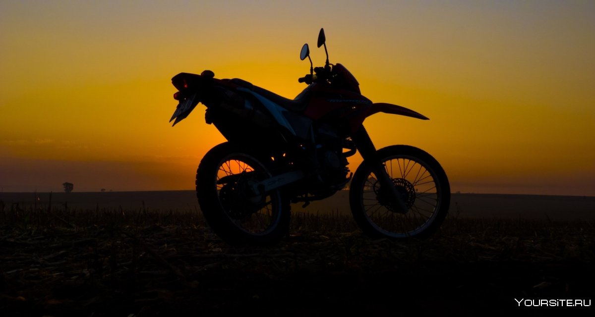 Мотоцикл в поле на закате