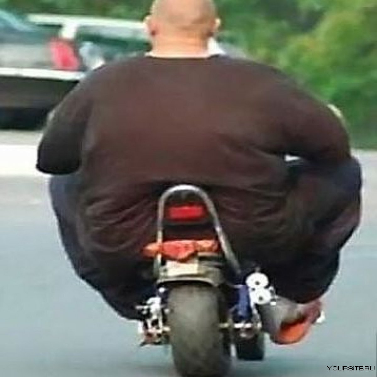 Толстый человек на мотоцикле