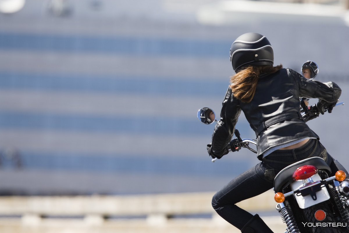 Девушка на мотоцикле в шлеме едет