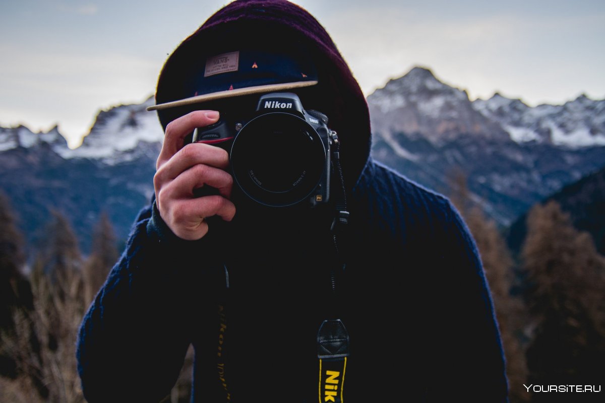 Парень в кепке смотрит на камеру