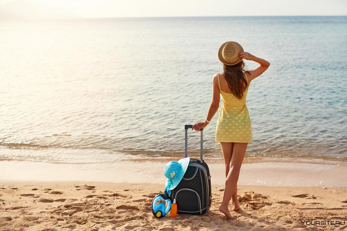 Девочка с чемоданом на фоне моря