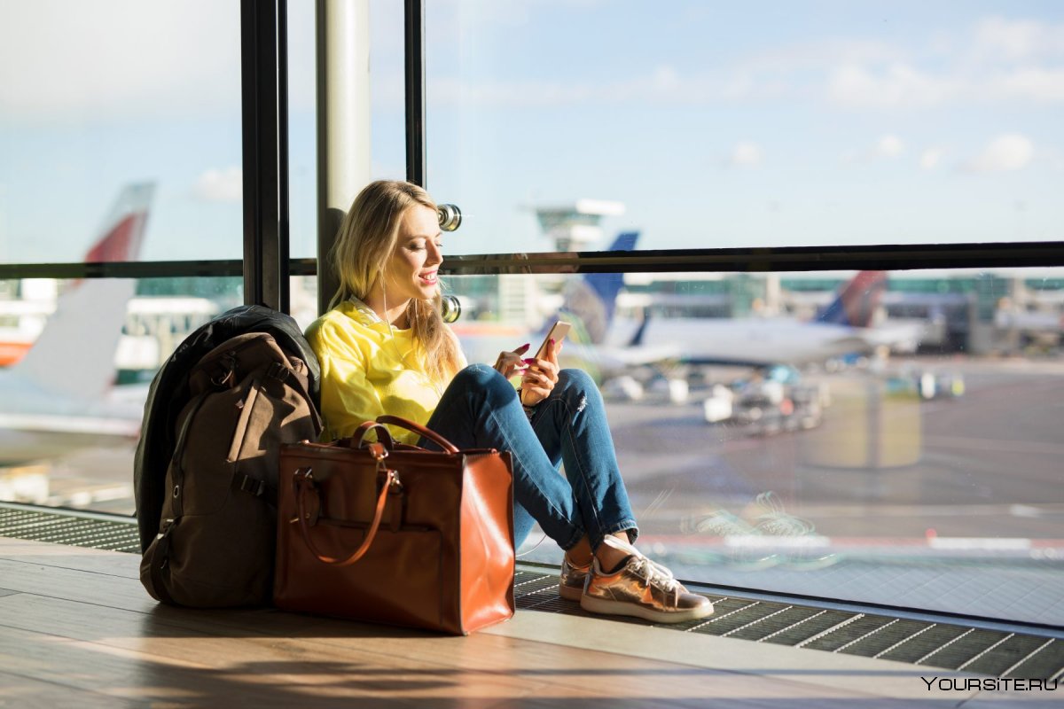 Девушка с чемоданом в аэропорту