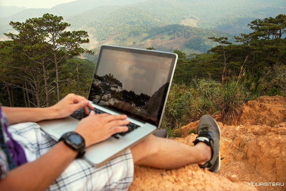 Человек с ноутбуком в горах