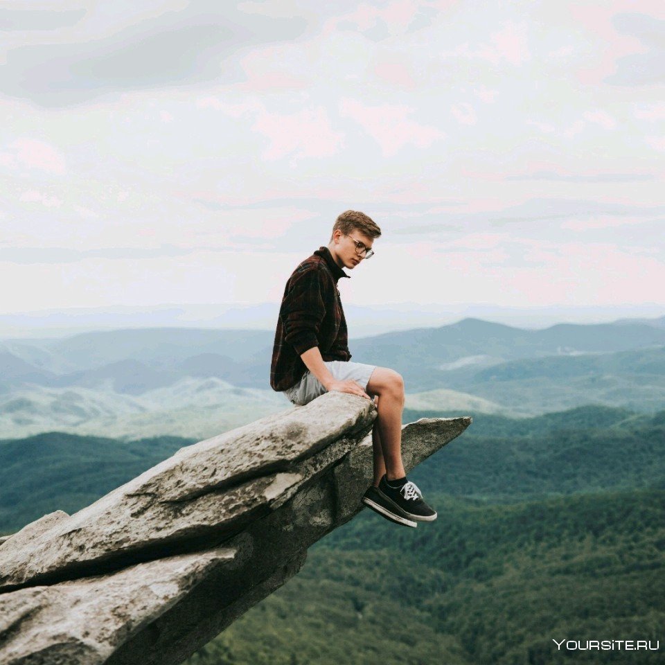 Мальчик сидит на скале