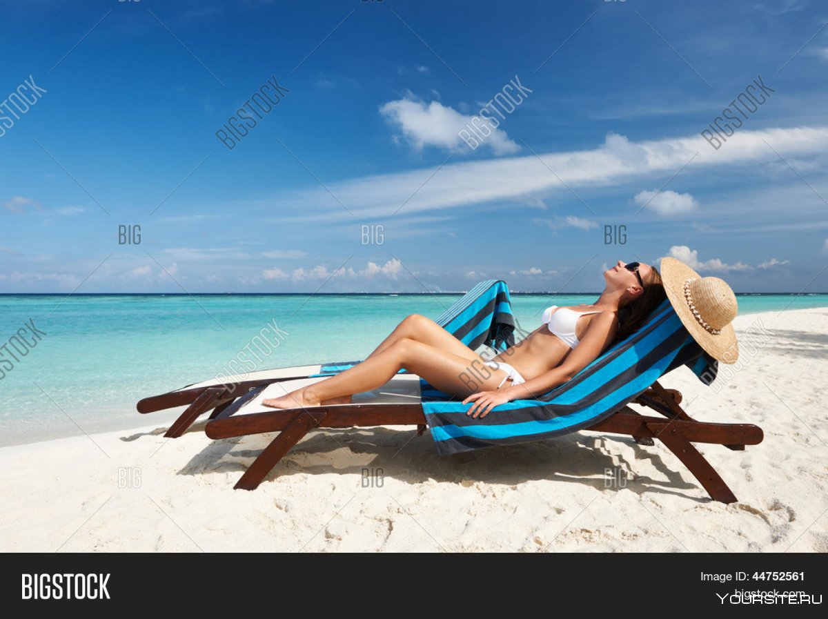 Девушка в шезлонге на пляже