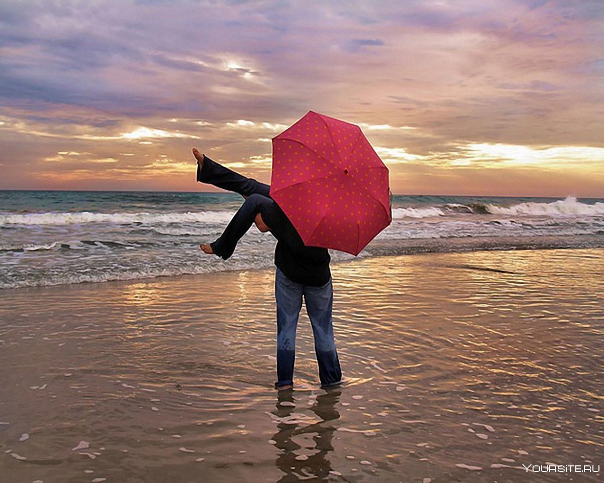 Девушка под зонтом на море