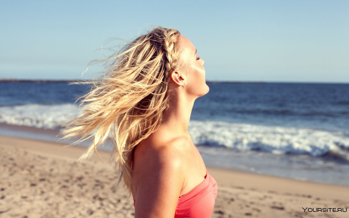 Блондинка на фоне моря со спины