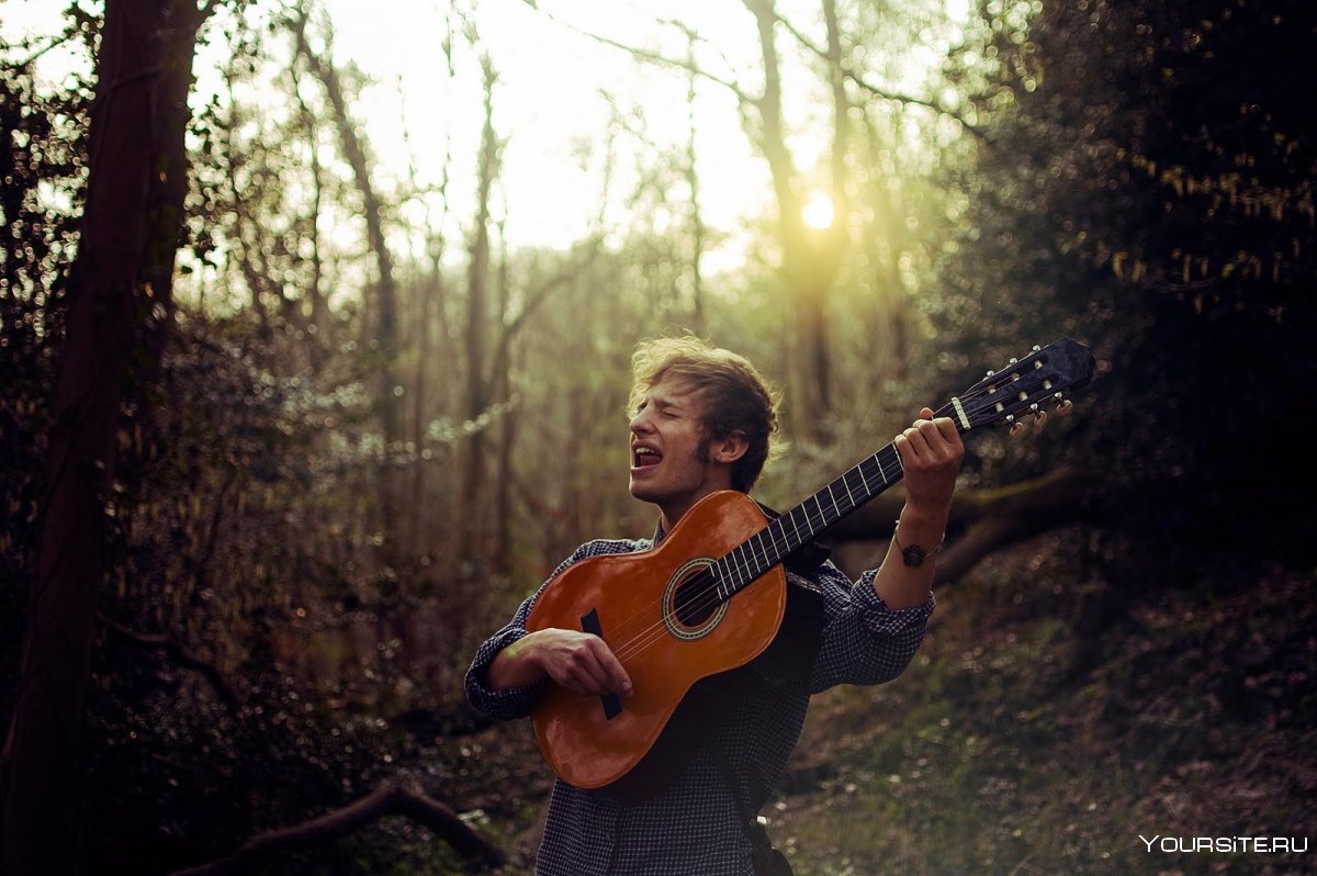 Человек с гитарой в лесу