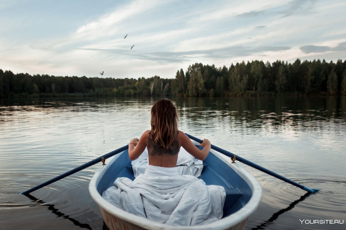 Женщина в лодке у озера