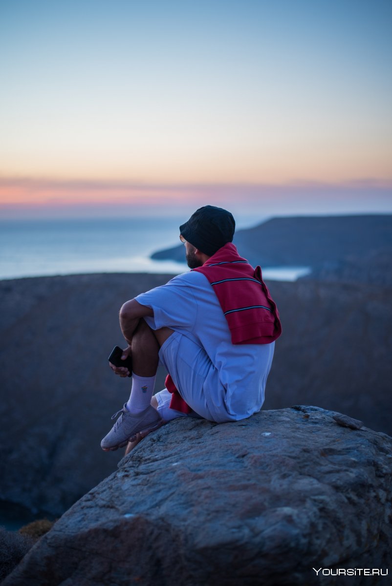Человек сидит на скале