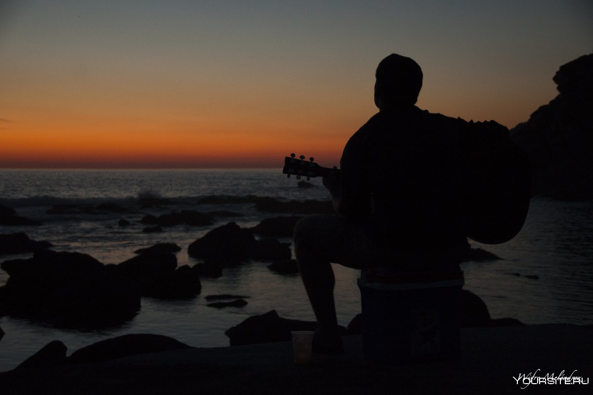 Парень с гитарой на фоне заката