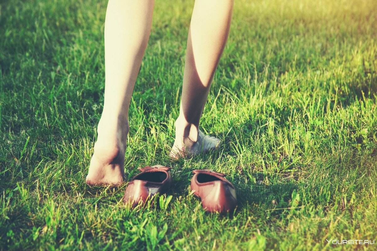 Девушка ходит босиком по траве