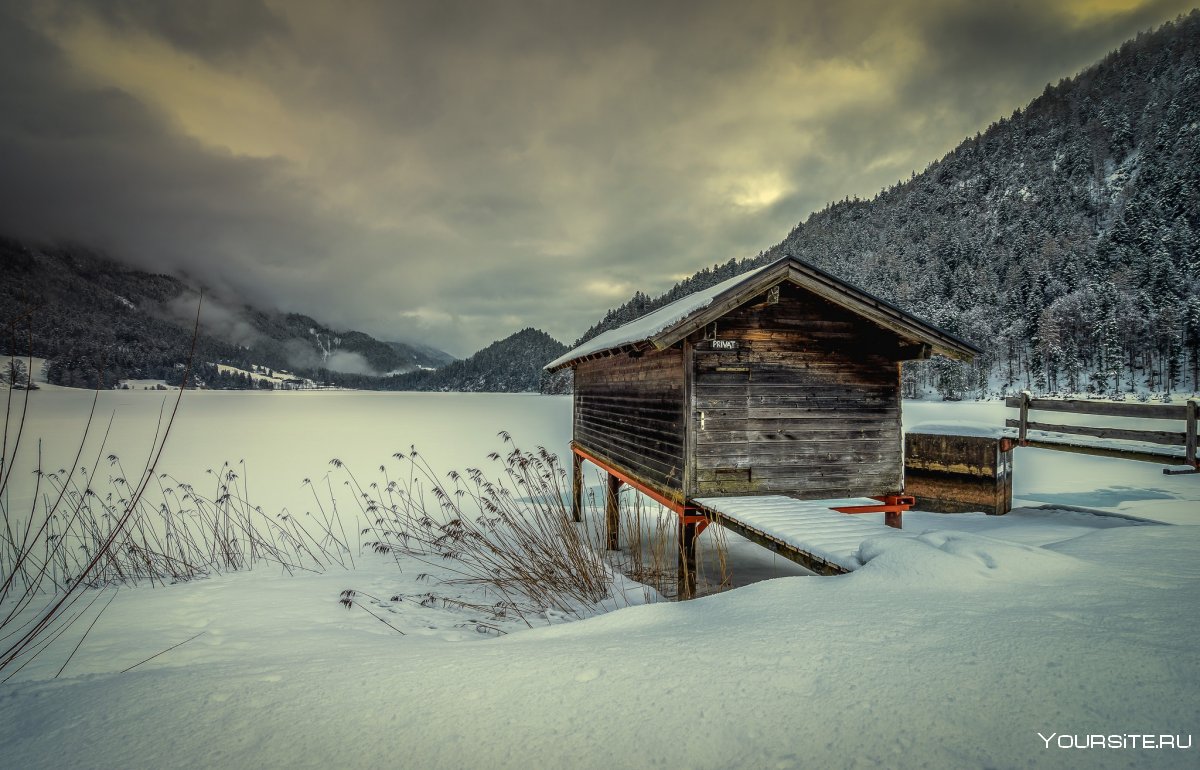 Дом у озера в горах зимой
