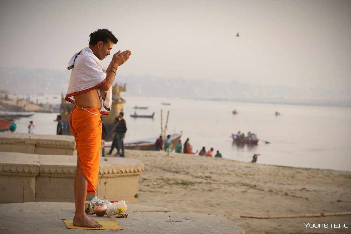 Человек молится на берегу моря