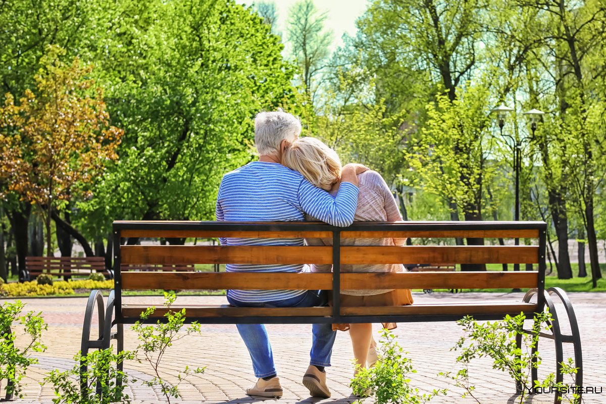 Пожилая пара на скамейке в парке