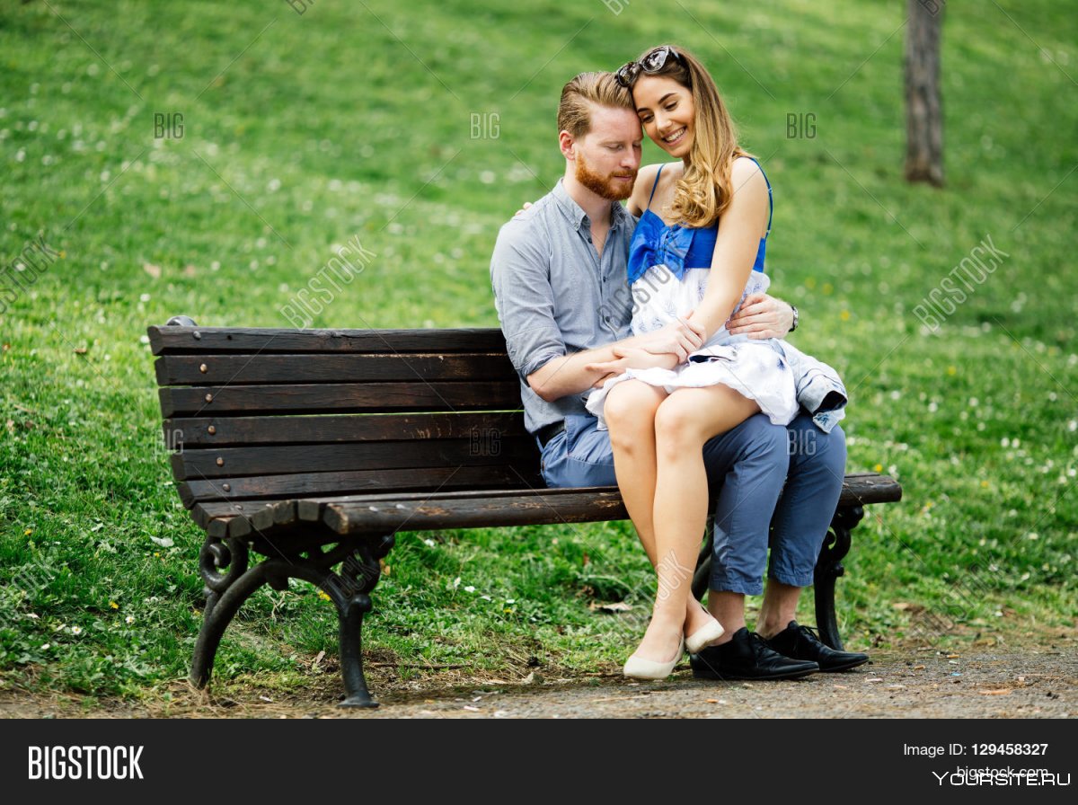 Пара сидит на скамейке в парке
