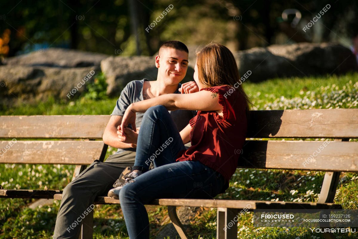 Молодая пара в парке на лавочке