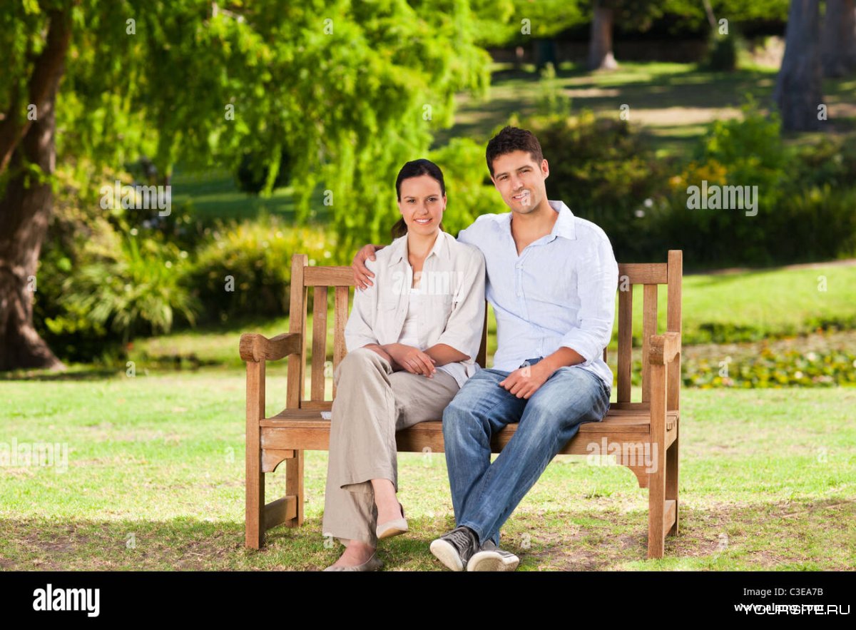 Молодая пара сидит на скамейке