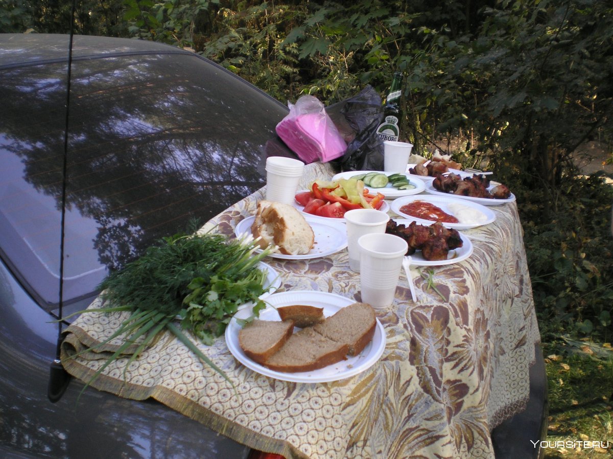 накрытый стол с едой на природе
