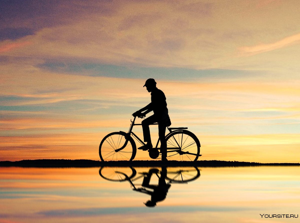 Человек на велосипеде на закате