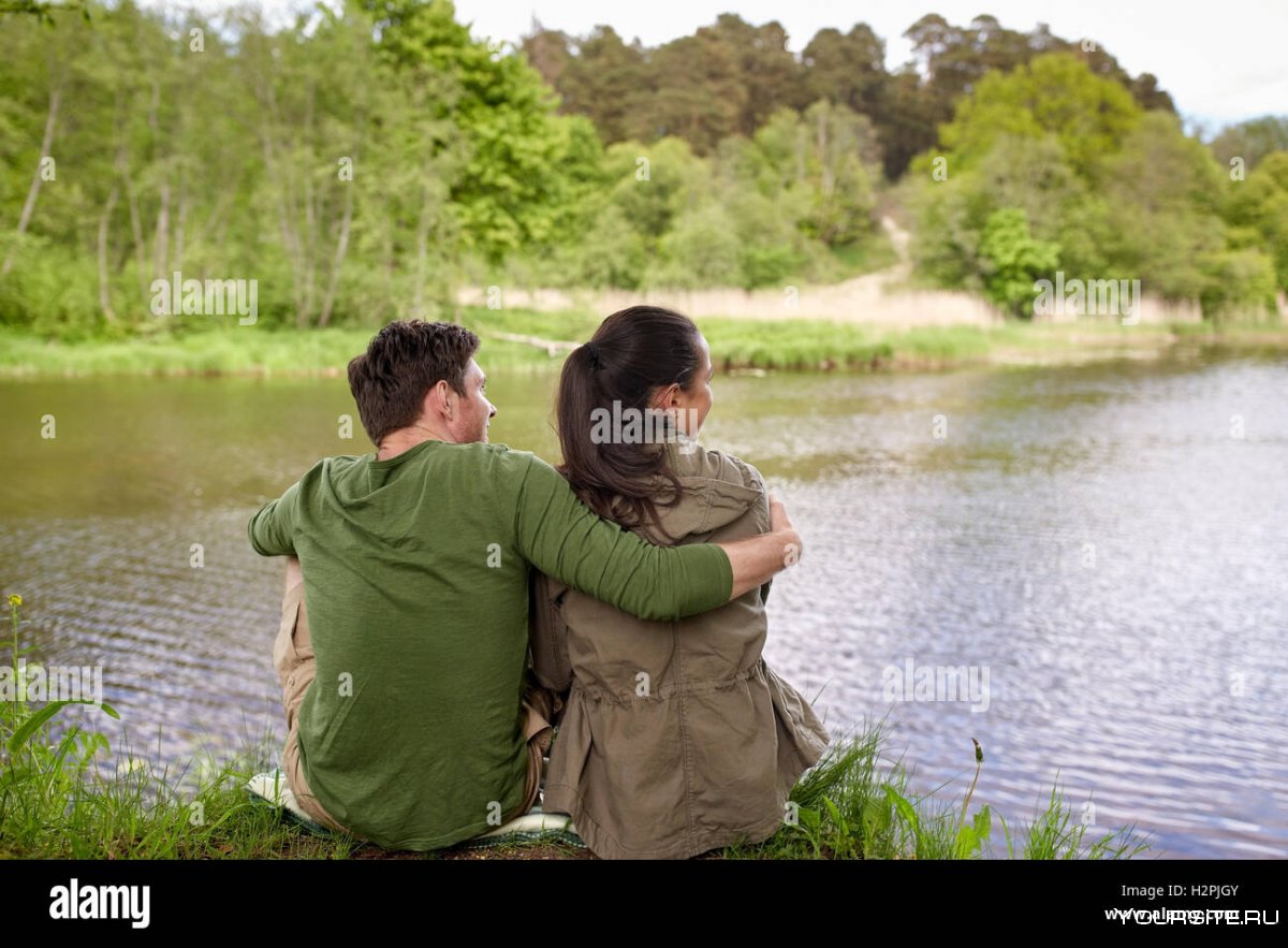 На берегу реки пара обнявшись