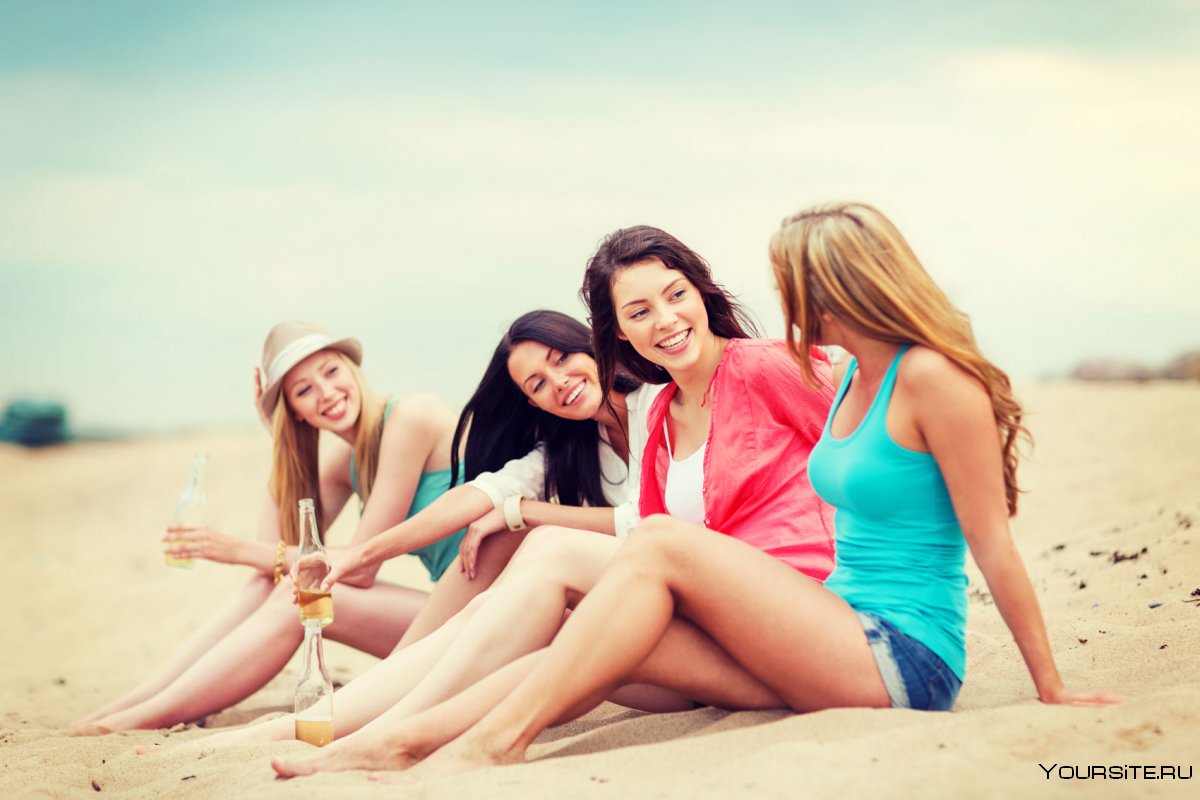 Четыре девушки лежат на пляже