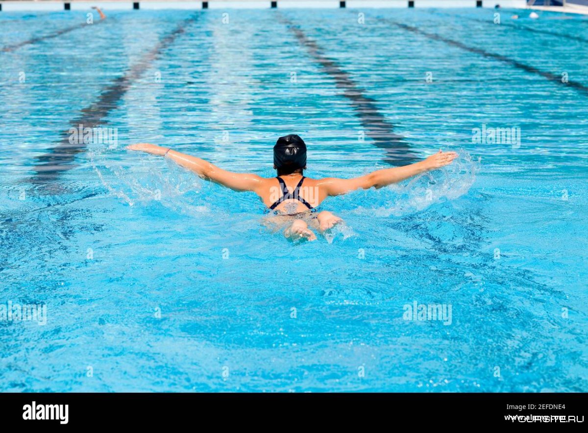 Девушка плывет в бассейне