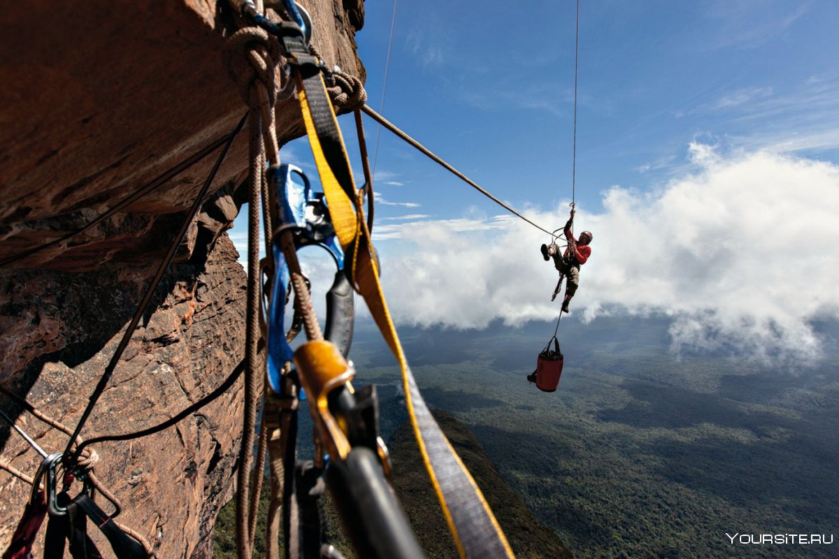 Взбирающийся к вершине альпинист
