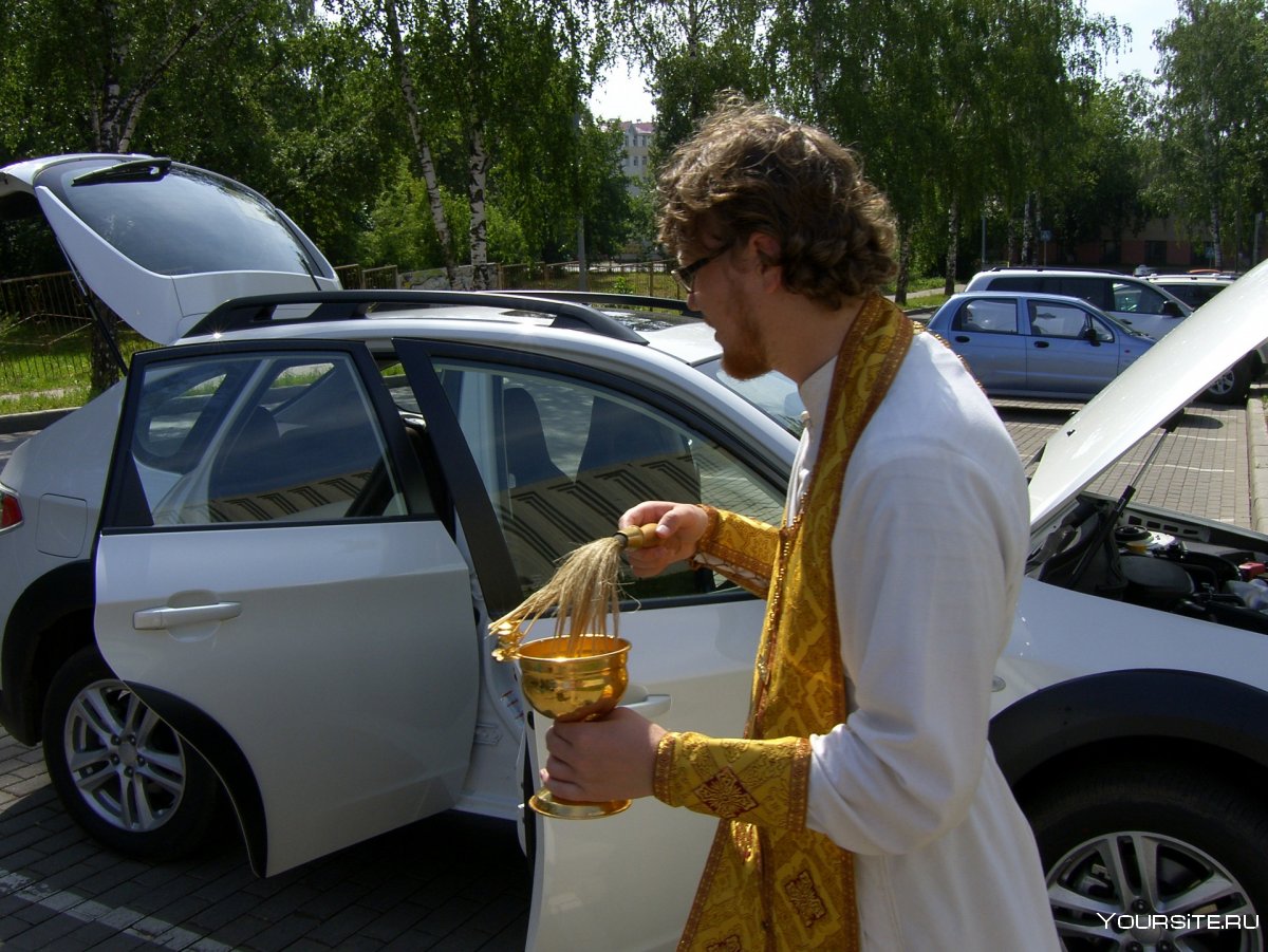 Священник освящает машину