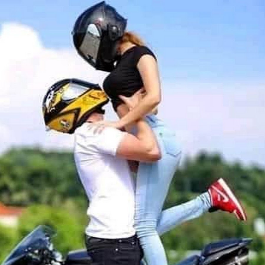 Райдер на мотоцикле целует девушку