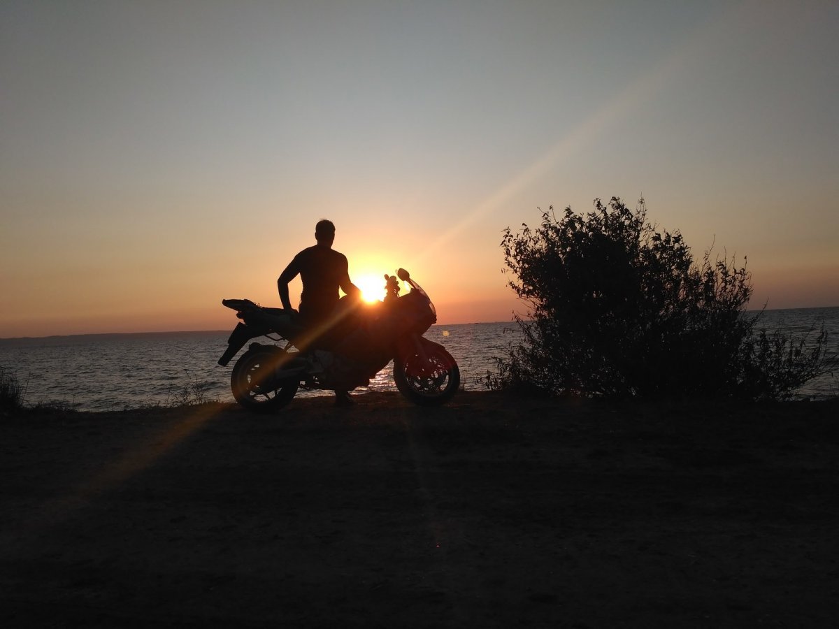 Парень на мотоцикле на закате