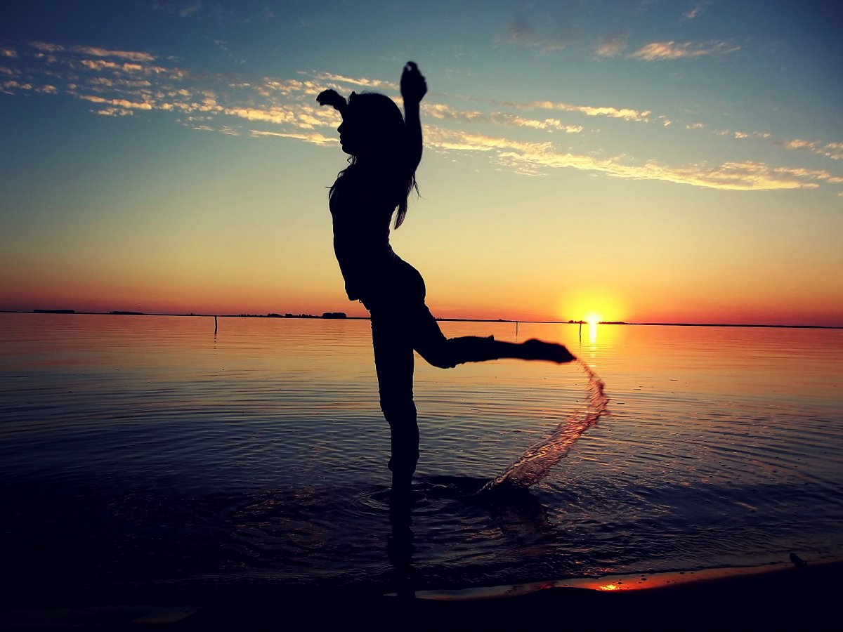 Девушка танцует на берегу