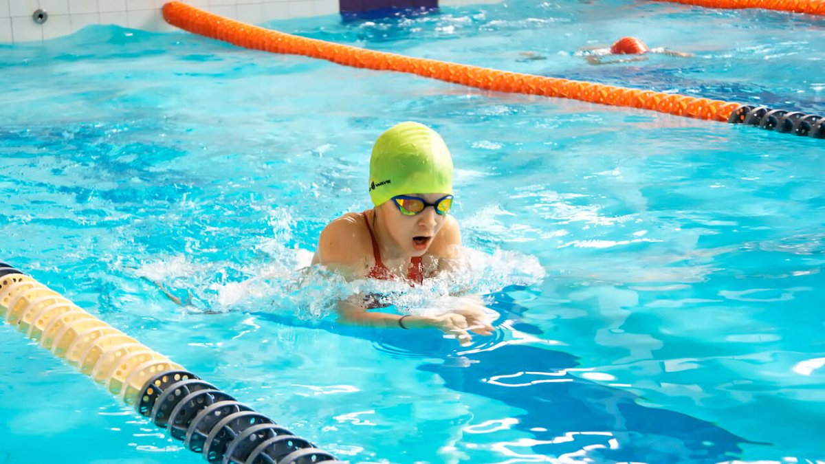 Девушка плывет в бассейне