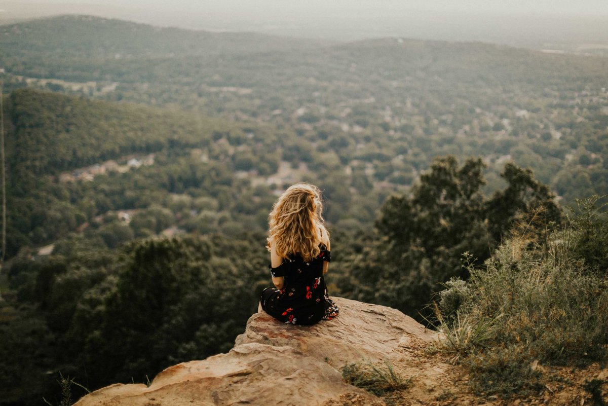 Девушка сидит на скале