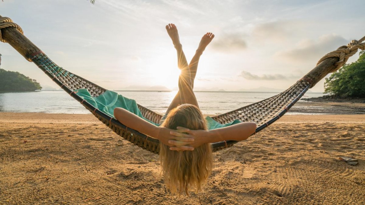 Man and woman laying in Hammock on Beach