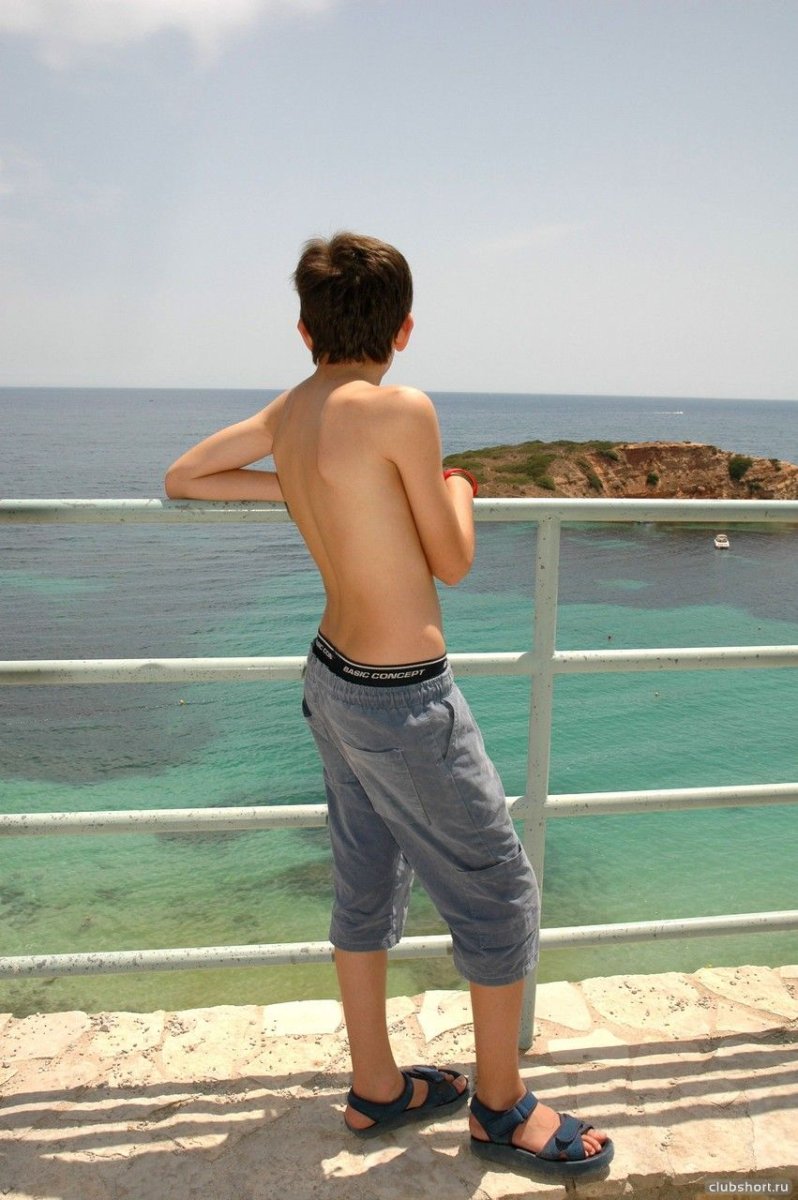 Мальчик в коротких и узких шортах на море