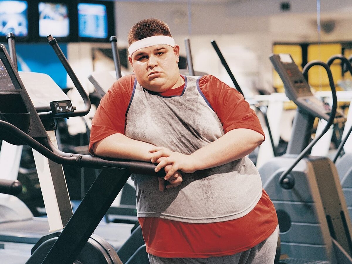 Толстый человек в спортзале