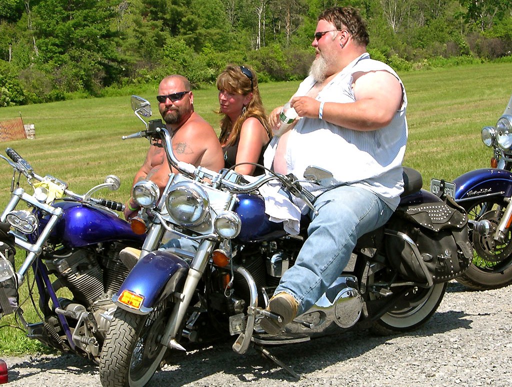 Толстый байкер на мотоцикле