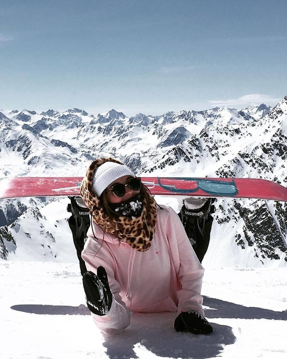 Девушка на сноуборде в горах